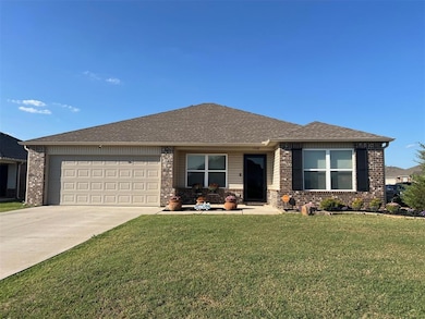 Single story home featuring brick, maintenance free siding, a front yard, a shingled roof, concrete driveway, and an attached garage