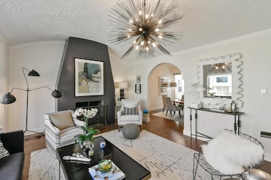 The main level features a sunny and welcoming living room with high, arched ceiling and wood-burning fireplace at the front of the home.