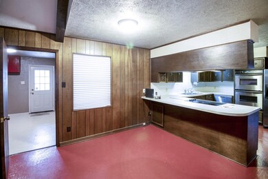 Kitchen features stainless double ovens and dishwasher. Off the breakfast room is an oversized laundry room with lots of storage.