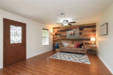 Living room featuring ceiling fan, wood finished f