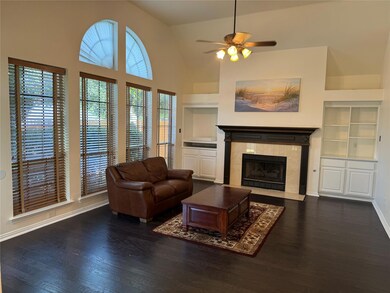 Family room featuring ceiling fan, high vaulted ceiling, built in features, dark hardwood floors, tiled fireplace, and fantastic views of the backyard and pool
