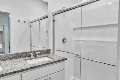 Full bath with a shower stall and vanity