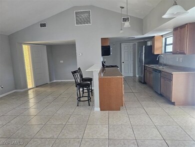 Kitchen with visible vents, appliances with stainless steel finishes, a kitchen breakfast bar, and a sink