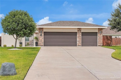 View of front of property with driveway, stone siding, an attached garage, and stucco siding