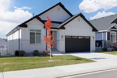 Modern inspired farmhouse with board and batten siding, an attached garage, driveway, and a front yard