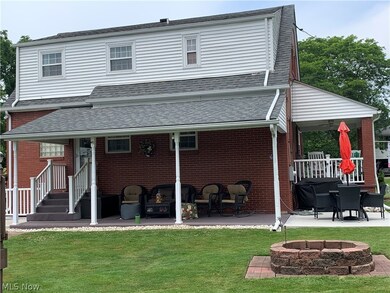 Back of house featuring a patio, a yard, and an outdoor fire pit