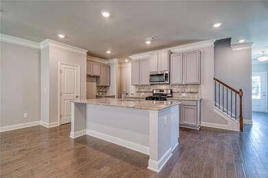 Kitchen featuring a kitchen island with sink, dark