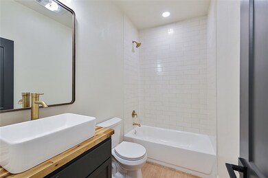 Bathroom featuring shower / tub combination, vanity, recessed lighting, and light wood finished floors