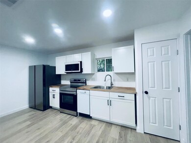 Kitchen featuring appliances with stainless steel finishes, white cabinetry, and light wood-type flooring