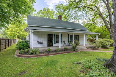 Back of property with a chimney, roof with shingle