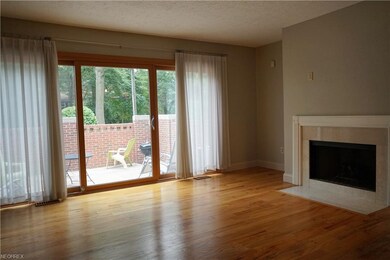 Living room with wood floors, leading out to the p