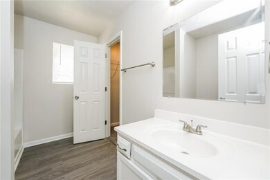 Full bathroom with vanity, wood finished floors, and a bath