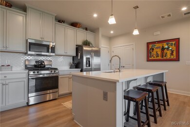 Kitchen featuring a center island with sink, hangi