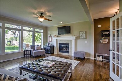 Large windows overlook the fenced backyard.