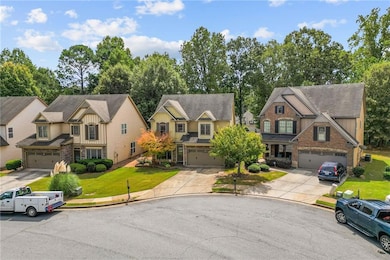Craftsman-style house featuring a front yard, driveway, board and batten siding, and stone siding