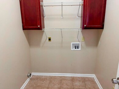 Laundry area with washer hookup, baseboards, hookup for an electric dryer, cabinet space, and light tile patterned floors