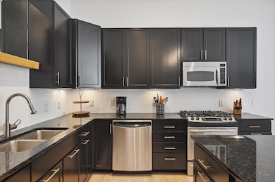 The kitchen features ample cabinet and counter space, under-cabinet lighting, gas cooktop and separate beverage fridge.