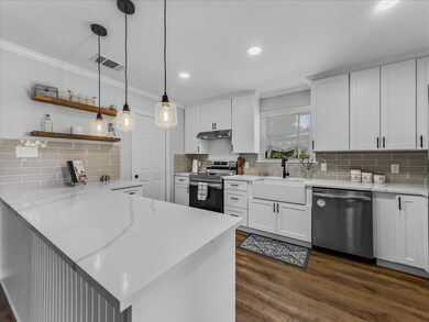 Kitchen featuring decorative light fixtures, dishwasher, range with electric stovetop, LVP flooring, walk in pantry and farmhouse sink