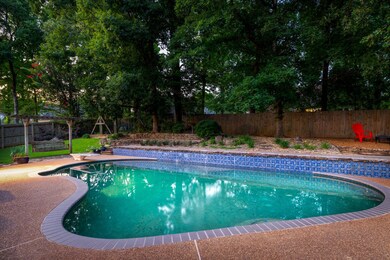 View of swimming pool with a fenced backyard and a diving board