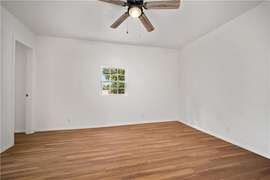 Unfurnished room with wood finished floors and ceiling fan