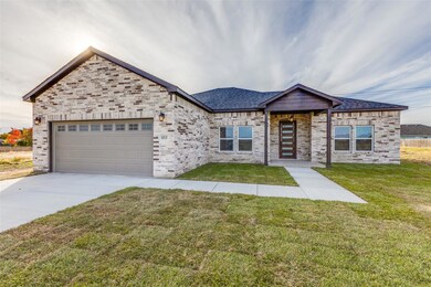 View of front of home with brick siding, roof with