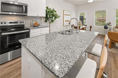 Kitchen with white cabinetry, tasteful backsplash,
