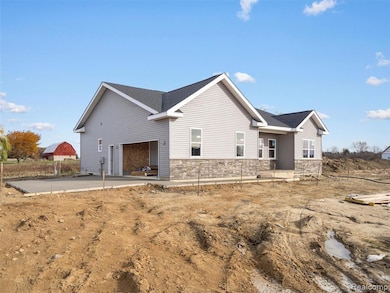 View of side of home with stone siding, roof with shingles, and a porch