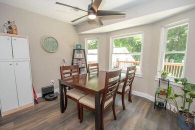 Dining room with dark wood-style flooring, a ceiling fan, and plenty of natural light