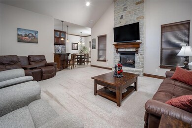 Living room featuring a stone fireplace, carpet fl