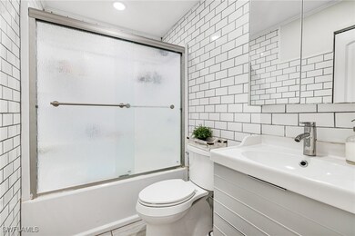 Bathroom featuring toilet, vanity, decorative back