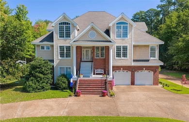 View of front facade with stairway, covered porch, driveway, an attached garage, and a shingled roof