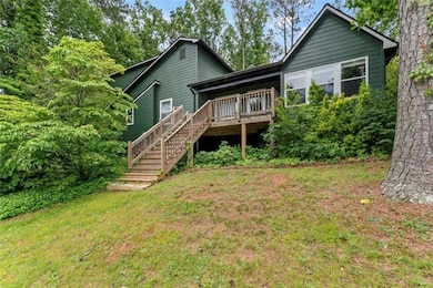 Rear view of house featuring stairway, a deck, and a lawn