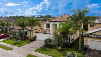 Mediterranean / spanish home featuring stucco siding, a front yard, a garage, and decorative driveway