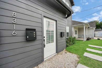 Modern hardware and a matte black mailbox elevate