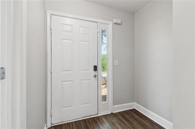 Entryway with baseboards and dark wood-style floor