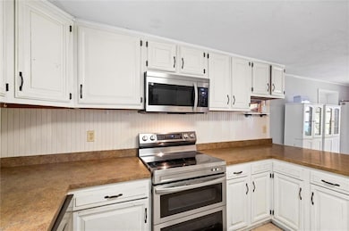 Kitchen featuring white cabinets and stainless ste