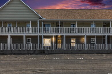 View of front of home with uncovered parking and roof with shingles