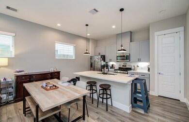 A modern, open-concept kitchen and dining area. Th