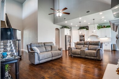Living room featuring high vaulted ceiling, arched walkways, dark wood-style floors, a ceiling fan, and recessed lighting