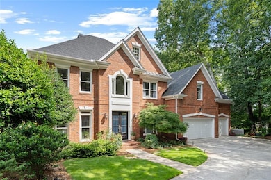 View of front of house with brick siding, concrete driveway, an attached 3 car garage, a front lawn, and a shingled roof