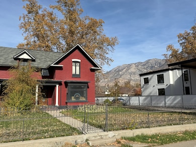 View of front facade with a fenced front yard, brick siding, and a mountain view