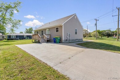 Rear view of property featuring a deck and a yard.