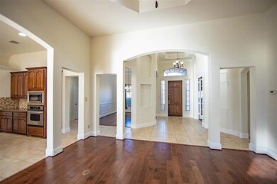 Entrance foyer with light wood-type flooring, a high ceiling, and an inviting chandelier