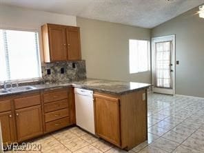 Kitchen with white dishwasher, a peninsula, light