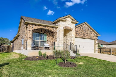 French country home featuring brick siding, a garage, concrete driveway, and roof with shingles
