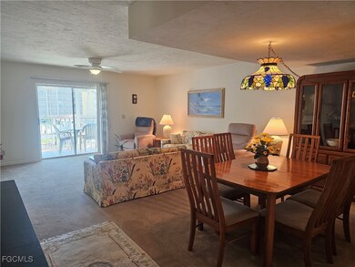 Dining area with carpet, a textured ceiling, and a ceiling fan