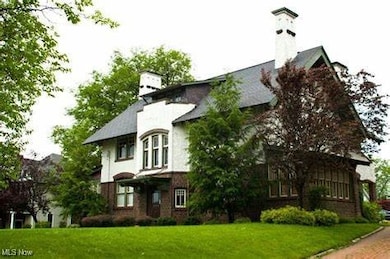 View of side of home featuring a lawn and a chimney