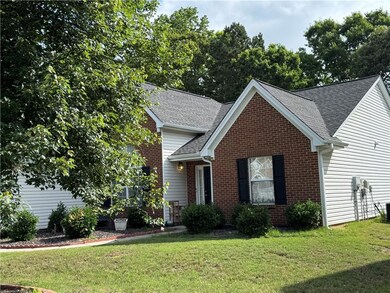 Traditional-style home with brick siding, a shingled roof, and a front lawn