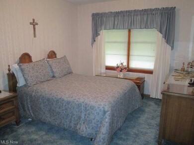 Master Bedroom with large window and hardwood floor under carpet