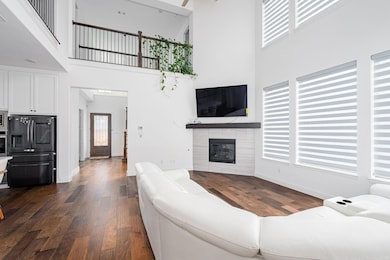 Living room with dark wood-type flooring, a firepl